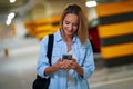 Adult woman using cellphone in underground parking lot Royalty Free Stock Photo