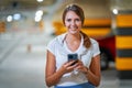 Adult woman using cellphone in underground parking lot Royalty Free Stock Photo