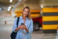 Adult woman using cellphone in underground parking lot Royalty Free Stock Photo