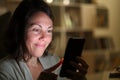 Adult woman using smartphone at night at home Royalty Free Stock Photo