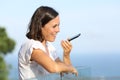 Adult woman using voice recognition on phone in a balcony Royalty Free Stock Photo