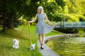 Adult woman walks two Maltese lapdogs on a leash. photo session in the park