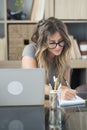 Adult woman work at home taking notes and using laptop computer - smart working alternative freedom office life Royalty Free Stock Photo