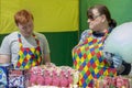 Adult woman and young man behind counter sell sweetsd.