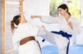 Two women training karate fight in studio