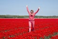 Adult womanjumping in red tulip field Royalty Free Stock Photo