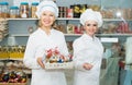 Adult women staff offering sweets Royalty Free Stock Photo