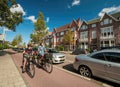 Adult women and young boy people riding bikes on Haarlem street fast commuting