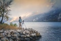 Adult young woman traveler professional photographer taking a picture of the landscape while standing with a camera on a tripod on Royalty Free Stock Photo