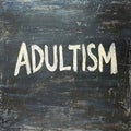 ADULTISM text related to the type of discrimination written on a blackboard Royalty Free Stock Photo