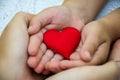 Adults and children hands holding a red heart, healthcare, love, organ donation, family insurance and CSR concept, World Heart Day Royalty Free Stock Photo