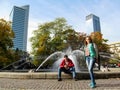 Adults guy and girl posing near fountain near Monument to Janusz Korczak in Swietokrzyski Park in Warsaw, Poland. Young people on Royalty Free Stock Photo