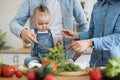 Adults and kid sprinkling vegan dish for family mealtime