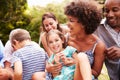 Adults and kids sitting on the grass in a garden Royalty Free Stock Photo