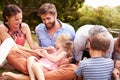 Adults and kids sitting on the grass in a garden Royalty Free Stock Photo