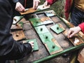 Adults putting together pieces of outdoor wooden puzzle. Educational walk