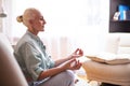 Adults and Seniors Lifestyle Concepts. Tranquil Caucasian Senior Female During Her Yoga Asana Training On Couch Indoors