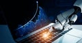 Advanced Artificial Intelligence Robot Writing on Laptop Keyboard with Data Visualizations in the Background Royalty Free Stock Photo