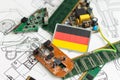 An advanced CPU printed with a national flag of Germany on a neon glowing electronic circuit board. 3D illustration of