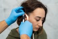 Advanced examination of a woman& x27;s ear using an otoscope at a doctor& x27;s appointment.