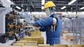 Advanced Factory Worker Robot Operating Machinery in a High-Tech Assembly Line with Humanoid Design and Safety Features for