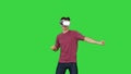 Advanced gamer in casual outfit playing dancing game in VG headset on a Green Screen, Chroma Key.