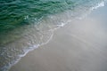 Advancing wave of foamy water onto beach