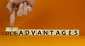 Advantages or disadvantages symbol. Businessman turns wooden cubes, changes the word Disadvantages to Advantages. Orange