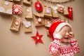 Advent calendar for kids. child in a Christmas cap and pajamas happy and playing peek a Boo Royalty Free Stock Photo