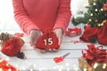 Advent calendar. Merry Christmas. Woman holds a red gift bag next to other surprises and gift boxes with numbers for Advent for