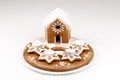 Advent candlestick with four lighted candles and christmas homemade gingerbread house on white background Royalty Free Stock Photo