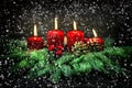 Advent decoration. Four red burning candles with falling snow Royalty Free Stock Photo