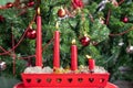 Advent greeting card. Four red burning candles in a beautiful candlestick. Decorated Christmas tree background. Christmas Holiday Royalty Free Stock Photo