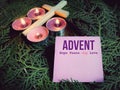 Advent hope peace joy love on paper with cross, candles and wreath background. Christmas preparation or Advent season concept. Royalty Free Stock Photo