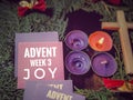 Advent week 3 joy text written on paper with the third candle lit background. Christmas preparation or Advent season concept. Royalty Free Stock Photo