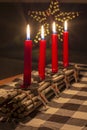 Advent wood sticks candle holder with silver stars with numbers 1,2,3,4. Four burning red candles. Christmas decoration Royalty Free Stock Photo