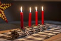 Advent wood sticks candle holder with silver stars with numbers 1,2,3,4. Four burning red candles. Christmas decoration Royalty Free Stock Photo