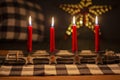 Advent wood sticks candle holder with silver stars with numbers 1,2,3,4. Four burning red candles. Christmas decoration Royalty Free Stock Photo