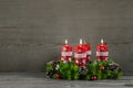 Advent wreath or crown with four red candles on wooden background. Royalty Free Stock Photo