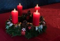 Advent wreath with four lighted red candles on a claret tablecloth Royalty Free Stock Photo