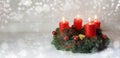 Advent wreath with four red burning candles and christmas decoration on rustic white wood, bokeh lights and blurred Royalty Free Stock Photo