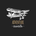 Adventure awaits motivational quote. Vintage retro airplane logo.Hand sketched aviation illustration in engraving style. Royalty Free Stock Photo