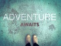 Adventure awaits word and feet wear white sneakers shoe on blue road