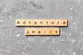 Adventure awaits word written on wood block. Adventure awaits text on cement table for your desing, concept Royalty Free Stock Photo