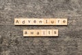 Adventure awaits word written on wood block. Adventure awaits text on cement table for your desing, concept Royalty Free Stock Photo