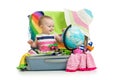 Adventure. Baby preparing for the journey. Child sits in suitcase and looks at globe. Royalty Free Stock Photo