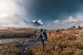 Adventure backpacker man with camera standing at mount Assiniboine in foggy on autumn forest in the morning