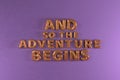 And so the adventure begins golden ballons text on violet wall background with copy space