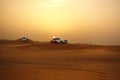 Adventure desert safari on sand dunes with off road vehicles at sunset