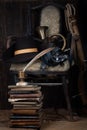 Adventure fiction - Vintage old broken wooden chair with hat, sword, bugle, books and fountain pen with inkpot Royalty Free Stock Photo